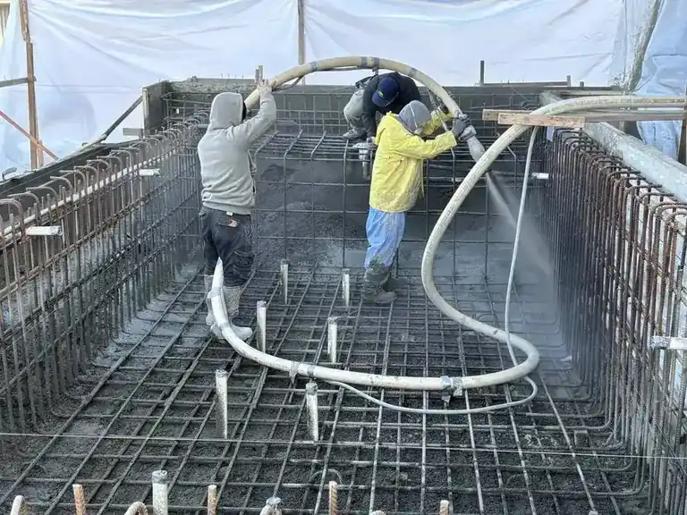 Crew members working on a pool shell during construction