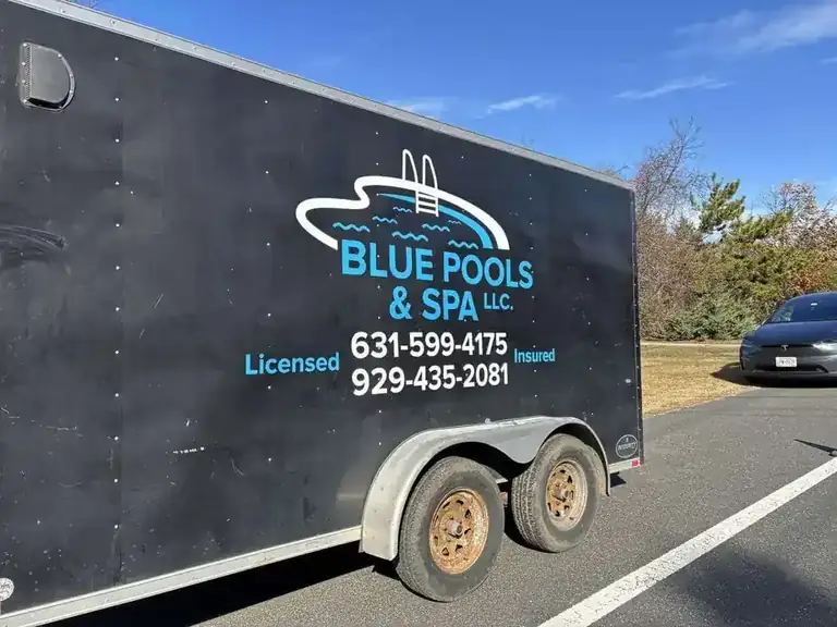 Blue Pools & Spa black work trailer with the company logo, phone numbers and Licensed and Insured lettering